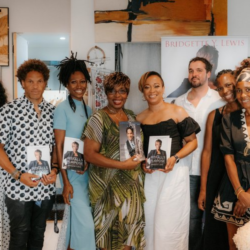 A group of smiling women and men are each holding a book by the author Bridgette Y. Lewis